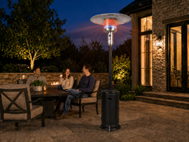 Legacy Heating KD07-S standing patio heater providing propane-powered warmth beside a family seating area in an American backyard.
