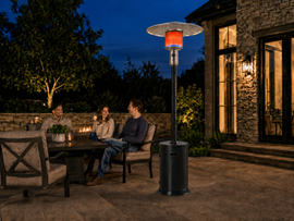 Legacy Heating KD07-S standing patio heater providing propane-powered warmth beside a family seating area in an American backyard.