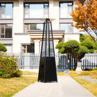 Legacy Heating CAPH-GT-S N hammered black pyramid flame patio heater displayed on a garden walkway outside a modern home in autumn.
