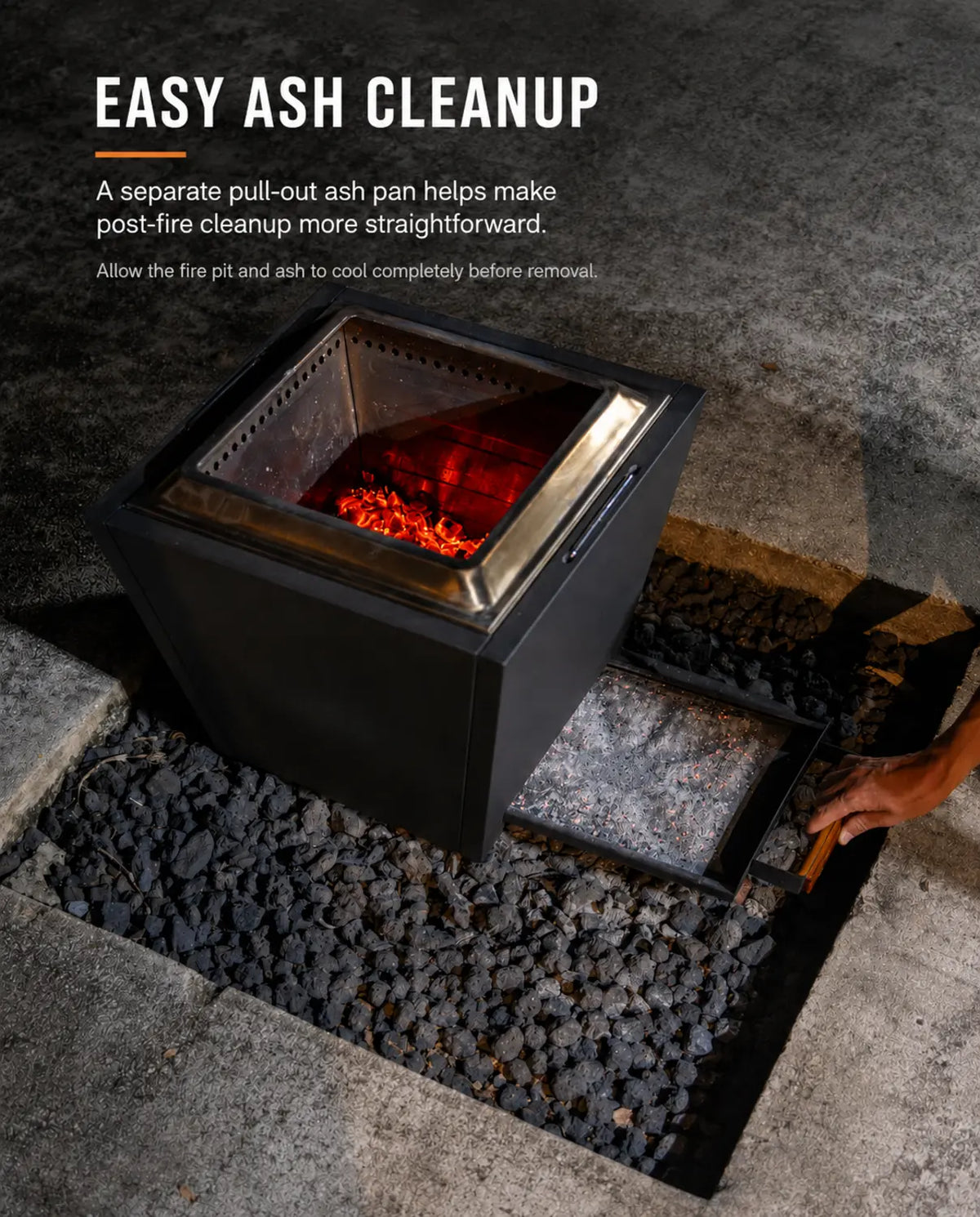 Open pull-out ash pan on a black LEGACY HEATING 20-inch Flat Smokeless Fire Pit, showing cooled ash and a wood-grip handle for easier post-fire cleanup.