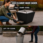 Woman using the pull-out ash pan of a LEGACY HEATING 25-inch black slatted smokeless fire pit for easier backyard cleanup, compared with lifting a traditional cylindrical fire pit insert.