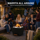 Nine family members, including grandparents and children, gather around a LEGACY HEATING 25-inch black slatted smokeless fire pit during a blue-hour backyard patio barbecue.