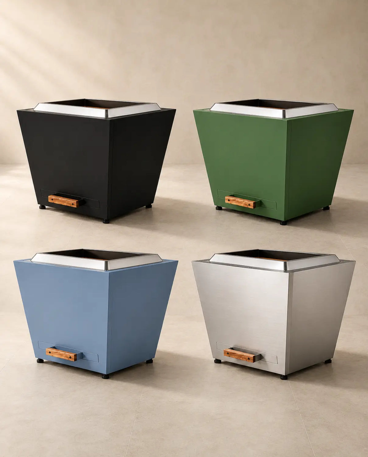 Four LEGACY HEATING 25-inch Flat Smokeless Fire Pits shown unlit in Black, Jewel Green, Haze Blue, and brushed Stainless Steel finishes, each with smooth, tapered steel panels, a raised stainless fire ring, and a wood-handled pull-out ash pan.