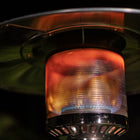 Close-up view of Legacy Heating CAPH-7-SS stainless steel patio heater burner with glowing flame, showing efficient heating element with perforated mesh design and warm orange glow for outdoor warmth.